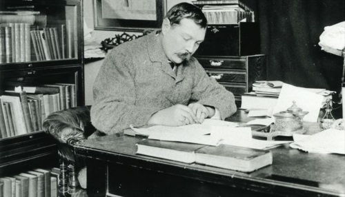 Arthur Conan Doyle writing at his desk